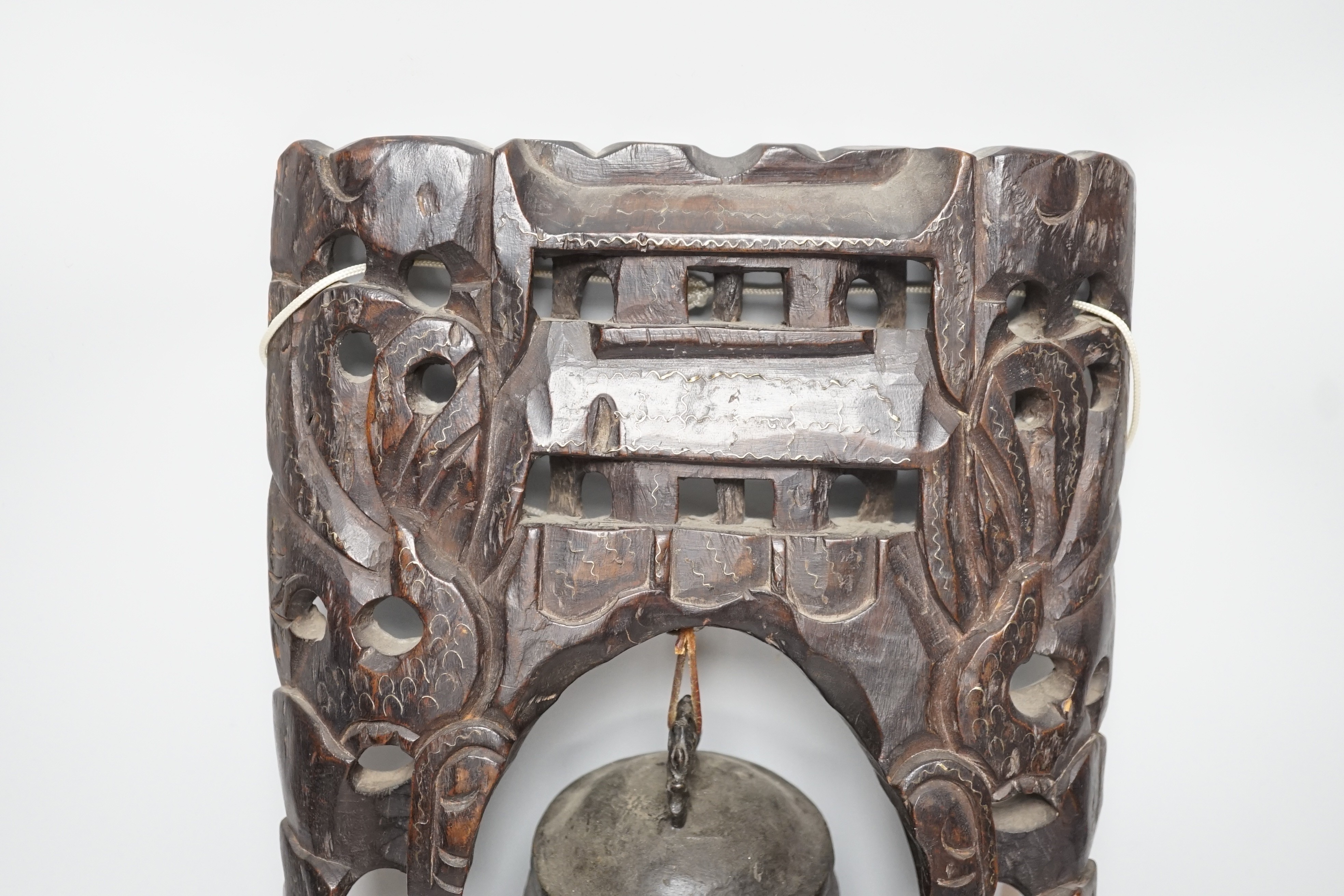 A Chinese bronze bell with wire inlaid carved hardwood stand, 44cm